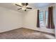 A bright bedroom with ceiling fan, neutral walls, carpeting and view to the outdoors through double windows at 8759 E Roundtree Ave, Greenwood Village, CO 80111
