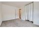 A sunlit bedroom with neutral walls, carpeting, and view to the outdoors at 8759 E Roundtree Ave, Greenwood Village, CO 80111