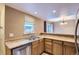 Cozy kitchen featuring stainless steel appliances, wood cabinets, and a convenient breakfast bar at 8759 E Roundtree Ave, Greenwood Village, CO 80111