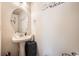 Charming powder room with pedestal sink, oval mirror, and neutral paint at 552 S Mobile Pl, Aurora, CO 80017