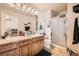 Primary bathroom featuring double sinks, granite countertops, and a walk-in shower at 552 S Mobile Pl, Aurora, CO 80017