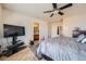 Bright bedroom with a ceiling fan, TV, plush rug, and ensuite bathroom at 552 S Mobile Pl, Aurora, CO 80017