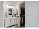 Well-lit bathroom featuring a modern vanity with drawers and open storage, and a closet at 1413 Ben Nevis Ave, Broomfield, CO 80020