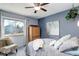 Cozy bedroom features a ceiling fan, large window, and comfortable furnishings at 1413 Ben Nevis Ave, Broomfield, CO 80020