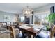 Open concept dining and living room with a modern light fixture, dining table, and access to outdoor patio at 1413 Ben Nevis Ave, Broomfield, CO 80020