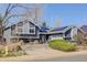 Charming home with solar panels, gray siding, brick accents, mature landscaping, and a spacious driveway at 1413 Ben Nevis Ave, Broomfield, CO 80020