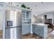 Open kitchen with stainless steel refrigerator, granite island, and view into the living area at 1413 Ben Nevis Ave, Broomfield, CO 80020