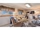 Living room with two windows, wood burning stove, television, and desk at 1413 Ben Nevis Ave, Broomfield, CO 80020