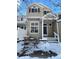 Two-story townhome with a charming front porch and snowy landscape at 2510 Concord Cir, Lafayette, CO 80026