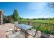 A flagstone patio with table and chairs overlooks a lush green lawn and open space on a sunny day at 14246 Piney River Rd, Broomfield, CO 80023