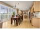 Sun-drenched dining area with wood floors, large windows, and an open view to the kitchen at 14246 Piney River Rd, Broomfield, CO 80023