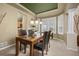 Dining area with a dark wood table, glass top, and view to a bright kitchen through a doorway at 14246 Piney River Rd, Broomfield, CO 80023