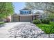 A two-story home boasts a three-car garage, gray siding, and stone accents, framed by green trees at 14246 Piney River Rd, Broomfield, CO 80023