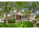 Charming home with stone accents, a covered front porch, manicured lawn, and mature trees at 14246 Piney River Rd, Broomfield, CO 80023
