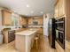 Bright kitchen features wood floors, a large island, and stainless steel appliances at 14246 Piney River Rd, Broomfield, CO 80023