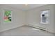 Neutral bedroom with carpet, two large windows, and baseboard heating at 4480 S Pennsylvania St, Englewood, CO 80113