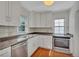 Bright kitchen features white cabinets, stainless steel appliances, and granite countertops, offering a clean and modern cooking space at 4480 S Pennsylvania St, Englewood, CO 80113