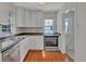 Well lit kitchen featuring stainless appliances, granite countertops, and white cabinets at 4480 S Pennsylvania St, Englewood, CO 80113