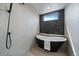 Modern bath with a black tub under a window with a hand held shower faucet at 1423 Xavier St, Denver, CO 80204