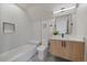 Modern bathroom featuring a tub, stylish vanity with storage, and white subway tile at 1423 Xavier St, Denver, CO 80204