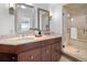 Elegant bathroom featuring double sinks, a marble countertop, and a glass-enclosed shower at 1891 Curtis St # 1820, Denver, CO 80202