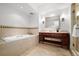 Bathroom featuring a cherry wood vanity, stone countertops, a soaking tub and a glass enclosed shower with decorative tile at 1891 Curtis St # 1820, Denver, CO 80202