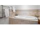 Relaxing bathroom featuring a standalone soaking tub with travertine tile and heated towel rack at 1891 Curtis St # 1820, Denver, CO 80202