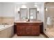 Elegant bathroom features double sinks, vanity, mirrors, tile, and a glass enclosed shower and bathtub at 1891 Curtis St # 1820, Denver, CO 80202