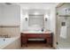 Bathroom featuring a cherry wood vanity, stone countertops, a soaking tub and a glass enclosed shower with decorative tile at 1891 Curtis St # 1820, Denver, CO 80202