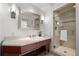 Bathroom featuring a cherry wood vanity, stone countertops, and a glass enclosed shower with decorative tile at 1891 Curtis St # 1820, Denver, CO 80202