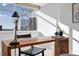 Bright office space with a large wooden desk, a modern lamp, a leather woven chair, and a downtown view at 1891 Curtis St # 1820, Denver, CO 80202