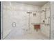 Accessible bathroom features marble-look tiles, bench seat, grab bars, and adjustable shower head at 130 N Pearl St # 1804, Denver, CO 80203