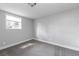 Neutral bedroom showcasing plush gray carpeting and natural light from the large window at 721 Forest View Rd, Monument, CO 80132