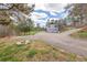 Long driveway leading to a two-car garage with lush surroundings and green space at 721 Forest View Rd, Monument, CO 80132