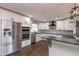 Modern kitchen featuring white cabinets, stainless steel appliances, and dark hardwood floors at 721 Forest View Rd, Monument, CO 80132