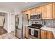 Kitchen featuring stainless steel appliances, wood cabinets and subway tile backsplash at 8801 W 65Th Ave, Arvada, CO 80004