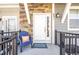 Charming front porch with colorful welcome mat and a blue chair with decorative pillow at 821 Robert St, Longmont, CO 80503