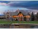 Luxury home featuring a stone facade, expansive windows, and manicured lawns along the waterfront at 1880 Mallard Dr, Broomfield, CO 80020