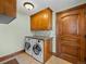 Well-equipped laundry room with wooden cabinets, granite countertop, tile backsplash, and tiled floor at 1880 Mallard Dr, Broomfield, CO 80020