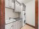 Functional laundry room with gray cabinets, granite countertop, a sink, and stacked washer/dryer units at 1880 Mallard Dr, Broomfield, CO 80020