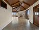 Expansive living room boasting a stone fireplace, wood-beamed ceilings, and multiple access points to the outdoors at 1880 Mallard Dr, Broomfield, CO 80020