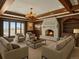 Cozy living room with a stone fireplace, wood-paneled walls, and lake views, creating a warm and inviting space at 1880 Mallard Dr, Broomfield, CO 80020