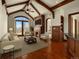 Elegant living room with vaulted ceilings, wood beams, a fireplace, and large windows with doors to the outside at 1880 Mallard Dr, Broomfield, CO 80020