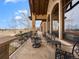 Covered patio with stone floors, stone pillars, and wrought-iron railings overlooking a beautifully landscaped yard at 1880 Mallard Dr, Broomfield, CO 80020