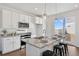 Bright kitchen with stainless appliances, granite counters, bar seating at the island, and sliding glass doors at 22063 E 38Th Pl, Aurora, CO 80019
