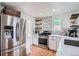 Bright kitchen boasts stainless steel appliances, white cabinetry, and modern backsplash at 7070 W 39Th Ave, Wheat Ridge, CO 80033