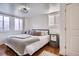 Sunlit bedroom features a large bed, modern lighting, and plank accent wall at 7070 W 39Th Ave, Wheat Ridge, CO 80033