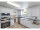Bright kitchen featuring white cabinets, gray countertops, stainless steel appliances, and ample storage, designed for functionality at 8800 W Kentucky Ave, Lakewood, CO 80226