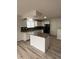 Bright kitchen featuring an island, white cabinets, and black appliances at 14598 E Evans Ave, Aurora, CO 80014