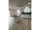Updated kitchen featuring an island, white cabinets, and wood-look flooring with a sliding door to the backyard at 14598 E Evans Ave, Aurora, CO 80014
